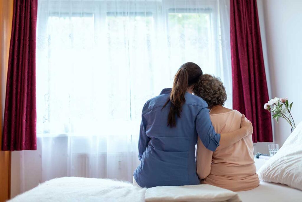 Older adult and family member reviewing care options with a nurse at a dining table.