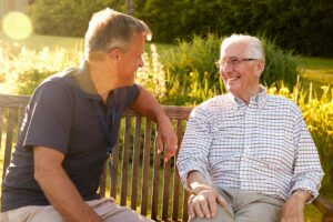 Older adult reviewing assisted living costs with a family member at a dining table.